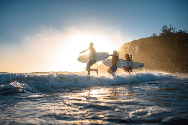 Gold Coast Surfers Running into Mist and Waves at Sunrise