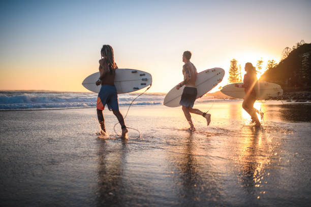 istock Gold Coast Surfers Running with Boards at Water’s Edge 1336192744