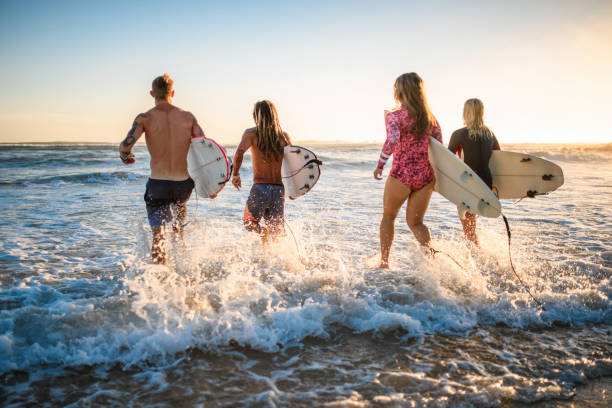 istock Surfers with Boards Running into Water at Burleigh Heads 1336192745