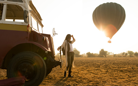 Traveler looking at hot air balloon over Bagan, Myanmar.