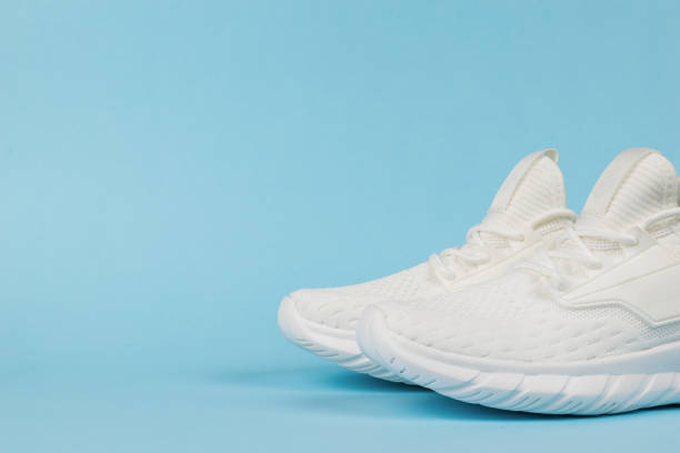 istock White stylish sports sneakers on a blue background. 1336207924