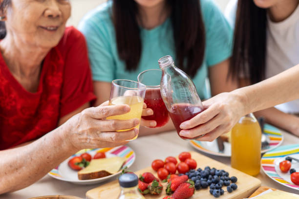 istock Group of friends having breakfast together drinking juices 1336215600