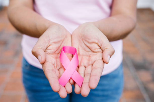 mains de femme tenant des rubans roses de sensibilisation au cancer du sein avec le ciel bleu comme arrière-plan en amérique latine - octobre rose photos et images de collection