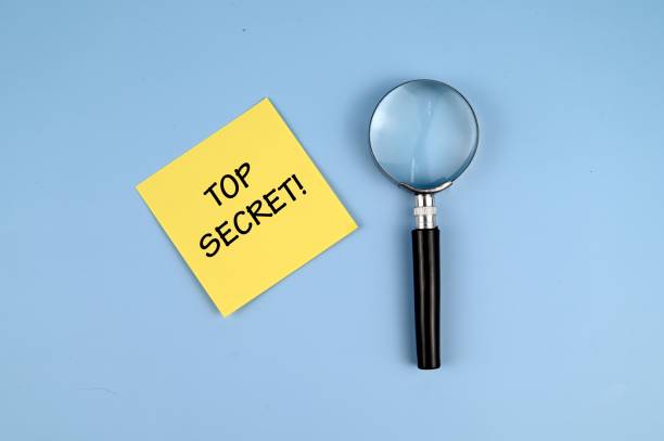 istock A memo paper with Top Secret text and a magnifying glass on blue background 1336217331