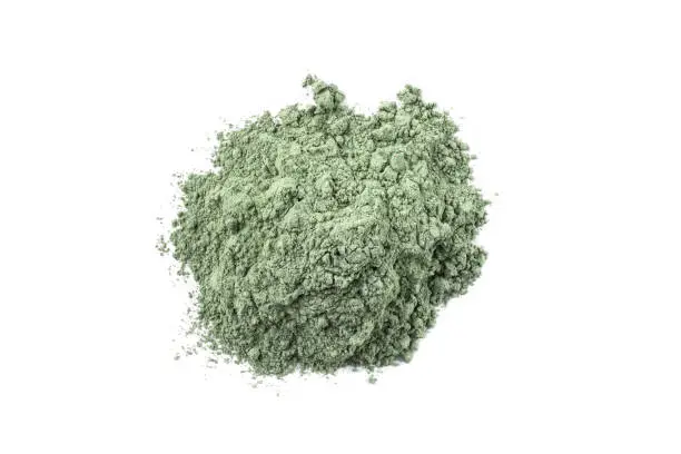 Photo of Dry green cosmetic clay isolated on white background.