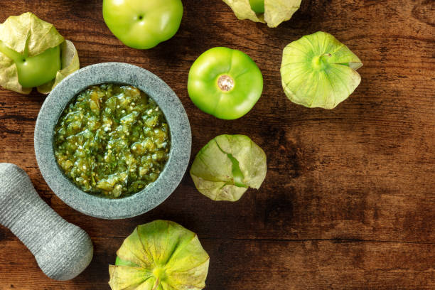 tomatillos, green tomatoes, with salsa verde, green sauce, in a molcajete - molho verde imagens e fotografias de stock