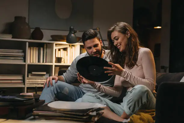 couple listening to a music on record player at home