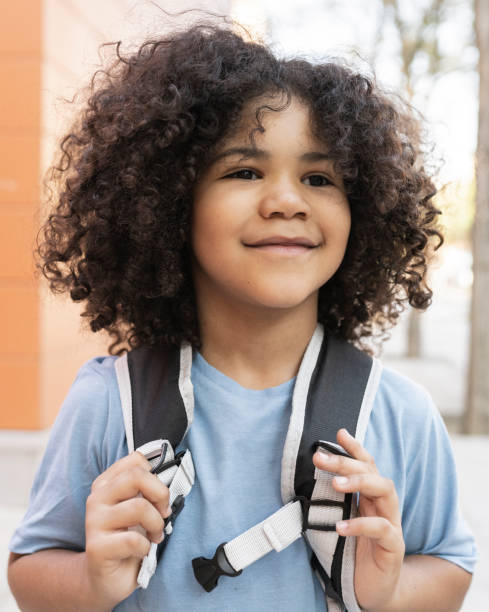 istock curly haired boy back to school, preschool, grabbing his backpack happy smiling 1336228354