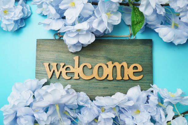 istock Welcome Sign and Flower Blooming Decoration on blue background 1336229021