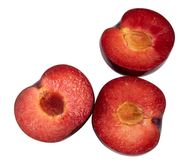 istock Three halves of a red plum isolated on a white background 1336229350