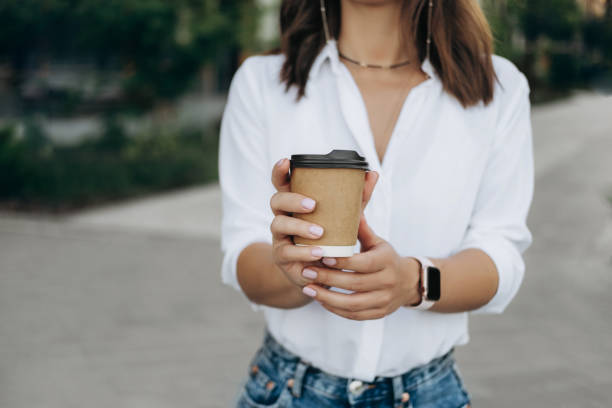 istock Woman holding coffee in paper cup 1336230252