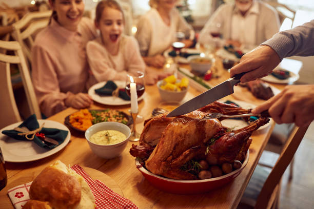 крупный план человека, вырезающего индейку на день благодарения во время семейного ужина за обеденным столом. - carving food стоковые фото и изображения