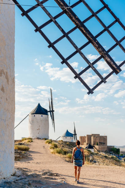 istock Young woman walking among old windmills and a castle 1336231693