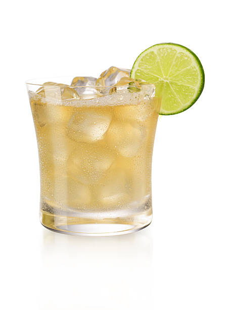 Display of a margarita on the rocks with a slice of lime  A cold margarita over Ice with a lime garnish, isolated on white tequila drink stock pictures, royalty-free photos & images