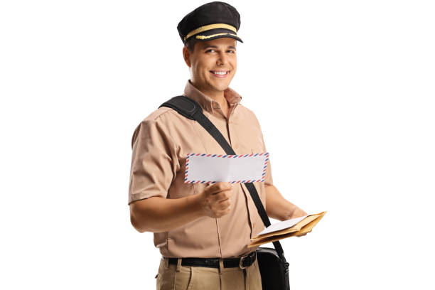 Mailman in a uniform with a bag and a letter smiling at camera isolated on white background