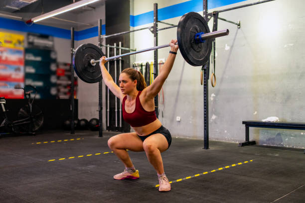 istock Fit young woman performing front squat with heavy barbell 1336232597