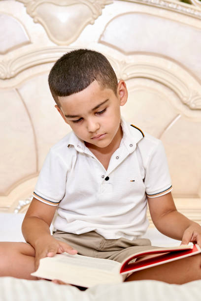 istock A cute child reading a book in the bed 1336233080