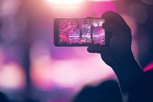 istock Person holding modern smartphone on a concert. 1336238464