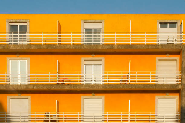Apartment buildings, yellow facade, balconies, clear sky background.  Pontevedra province, Galicia, Spain.