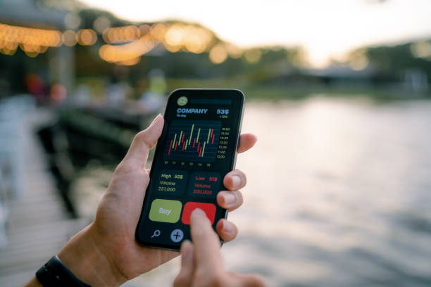 Young experts analyze financial charts on smartphones. Businessman reading financial trading data on wireless communication device. operating budget stock pictures, royalty-free photos & images