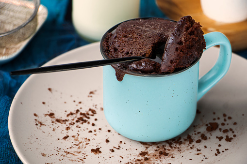 mugcake is microwaved. Homemade cupcake in a mug is on a plate. Chocolate brownie mug cake. Easy cooking concept, microwave baking. muffin chocolate. High quality photo