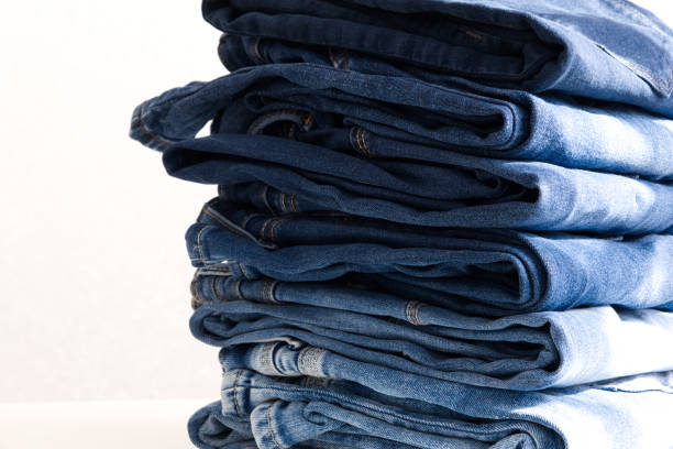 istock a pile of blue jeans on light background. Sunlight. Close up 1336241987