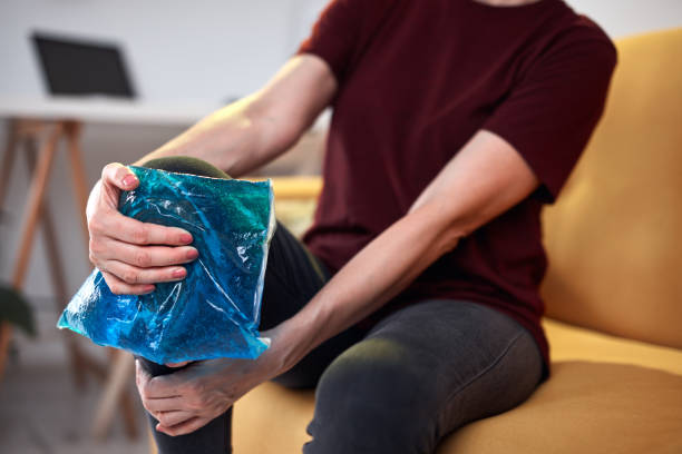 femme avec une blessure de douleur au genou à la maison en utilisant le pack de gel de glace. - ice women ice pack physical injury photos et images de collection