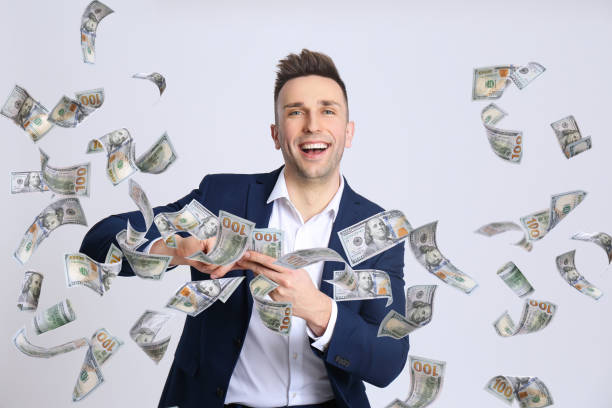 Happy young man with money on light background Happy young man with money on light background money rain stock pictures, royalty-free photos & images