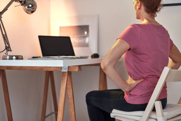 istock Woman working on a laptop at home and having problems with hips, back and stomack ache. 1336244428
