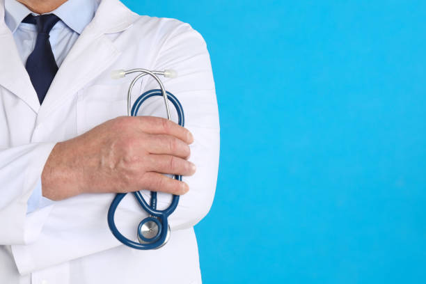 istock Senior doctor with stethoscope on blue background, closeup, space for text 1336244449