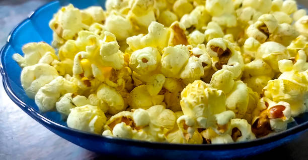 istock Fresh popcorn in a blue bowl on wooden table 1336246705
