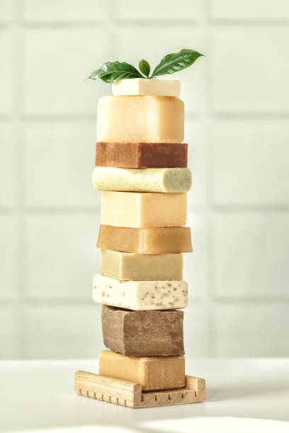 Stack of assorted natural soap bars on white bathroom countertop