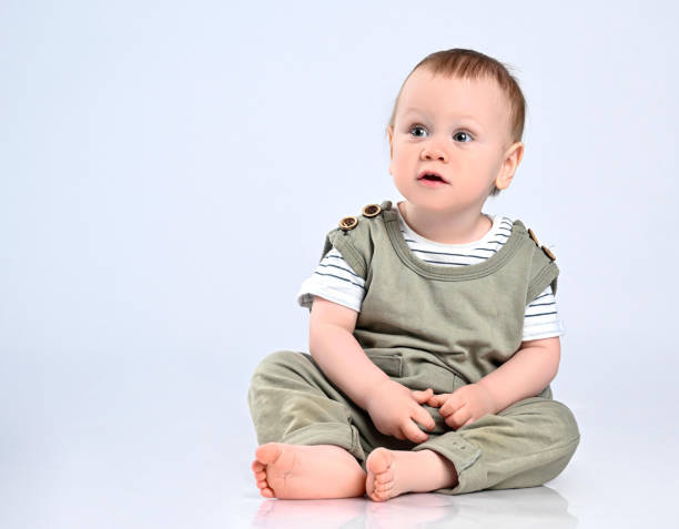 istock Happy child is sitting on floor, isolated over white 1336249024