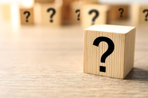 istock Cube with question mark on wooden background, closeup. Space for text 1336250585