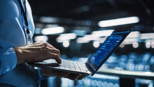 data center programmer using digital laptop computer, maintenance it specialist. cloud computing server farm system administrator working on cyber security for iaas, saas, paas. closeup focus on hands - technicus stockfoto's en -beelden