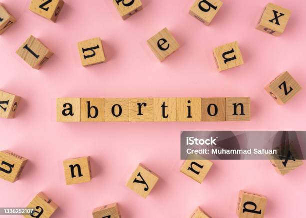 Abortion Word On Wooden Block Flat Lay View On Light Pink Background Stock Photo - Download Image Now