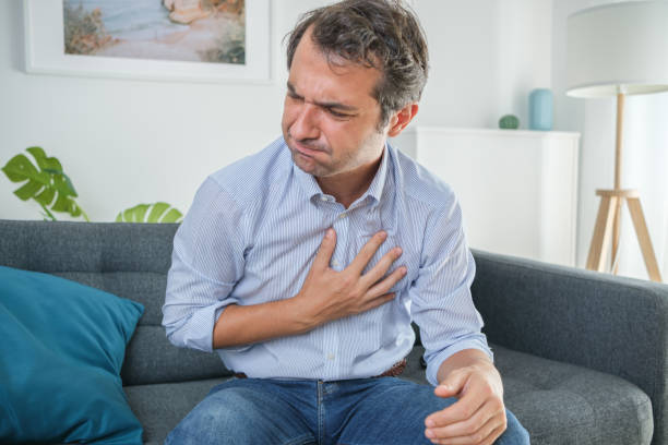 man suffering chest pain at home and feeling bad - chest pain imagens e fotografias de stock