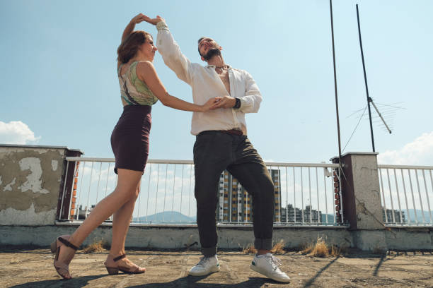 istock Young dancing couple dancing on the rooftop of a building 1336252348