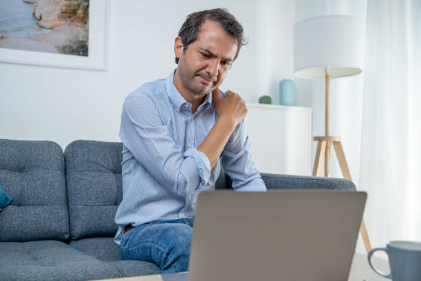 istock Man working from home feeling backache sitting on the sofa 1336252374