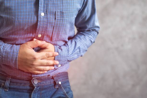 un joven en edad de trabajar con dolor abdominal. gastritis crónica. concepto de flatulencia - relieve fotografías e imágenes de stock