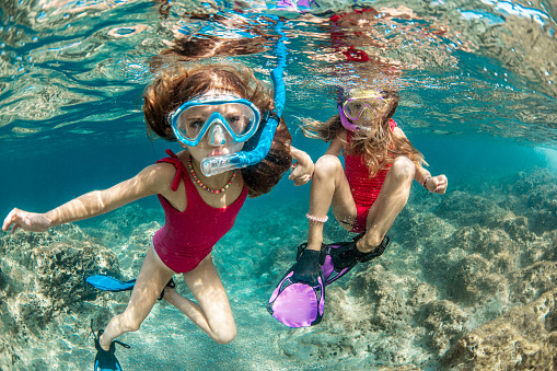 Asian woman on a snorkeling trip at Samaesan Thailand. dive underwater with fishes in the coral reef sea pool. Travel lifestyle, watersport adventure, swim activity on a summer beach holiday