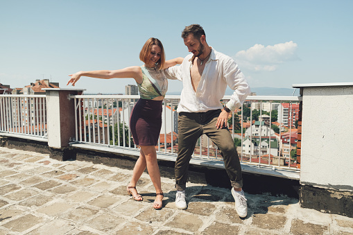 Young dancing couple dancing bachata and salsa on the rooftop of a building