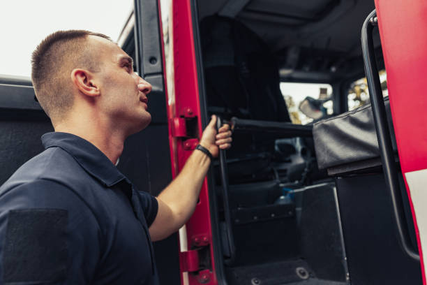 istock Fireman by fire truck using professional firefighting equipment 1336255331