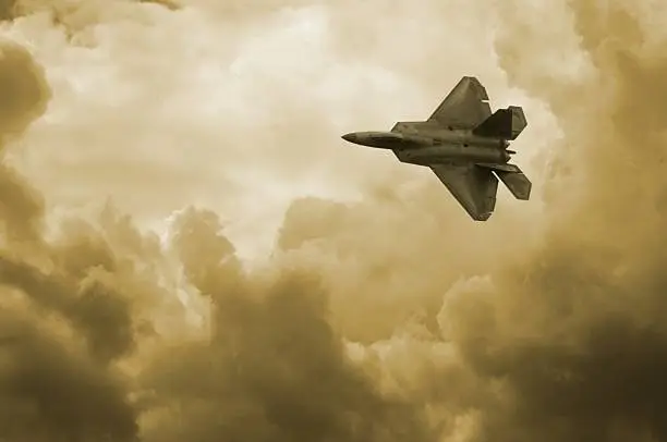 An F22 Fighter jet cuts across the sky.