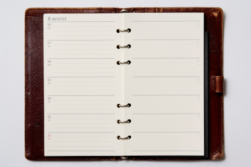 Close-up shot of opened blank leather personal organizer isolated on white background.