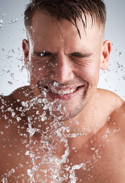 istock Studio shot of a handsome young man washing his face against a grey background 1336259775