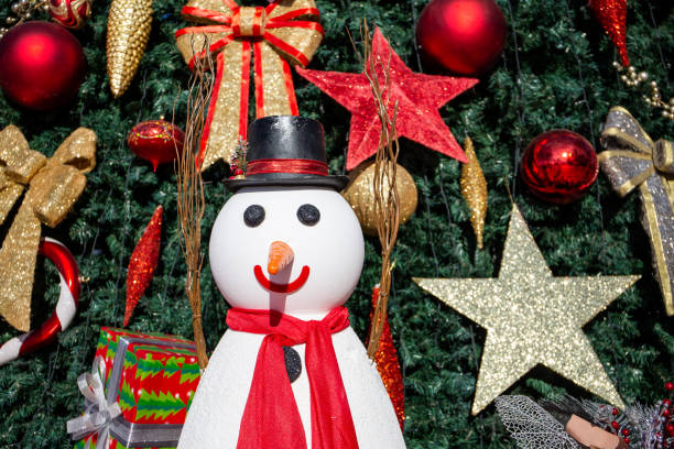 istock Snowman figurine, with christmas tree decorations in the background. 1336261208