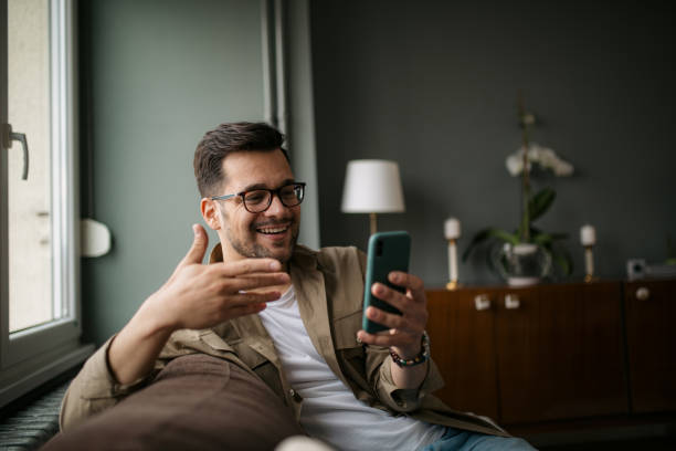 istock Happy young Caucasian man at home, using a smart phone 1336263780
