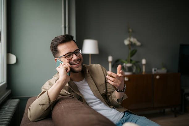 istock Happy young Caucasian man at home, using a smart phone 1336263786