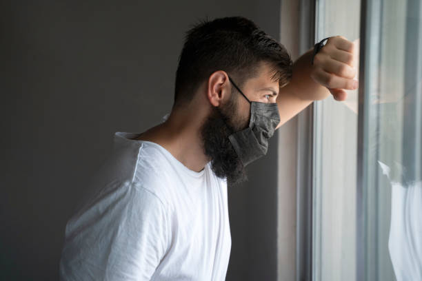 istock Young man wearing a protective face mask staying at home under quarantine during Coronavirus outbreak 1336263932